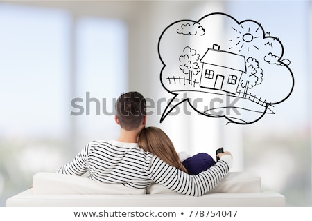 Stok fotoğraf: Young Couple Sitting On Sofa And Dreaming