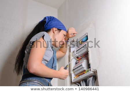 [[stock_photo]]: Female Electrician With A Fuse Box