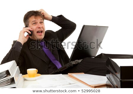 Foto stock: Businessman Sitting Behind Desk Is In Despair Pulling His Hair