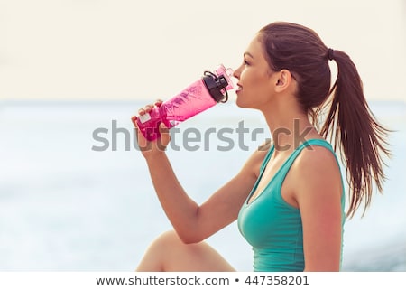 Foto stock: Young Fitness Woman With A Bottle Of Water Looking To Side