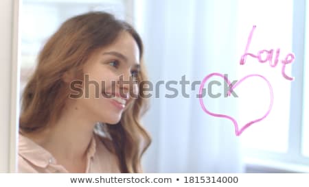 Foto stock: Ermosa · mujer · pintando · lápiz · labial · corazón · en · espejo