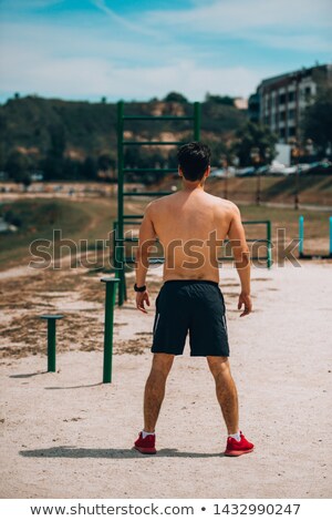 Stok fotoğraf: Portrait Of A Young Shirtless Sportsman Warming Up Before Jogging