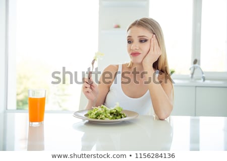 Сток-фото: Woman Looking At A Leaf Of Salad