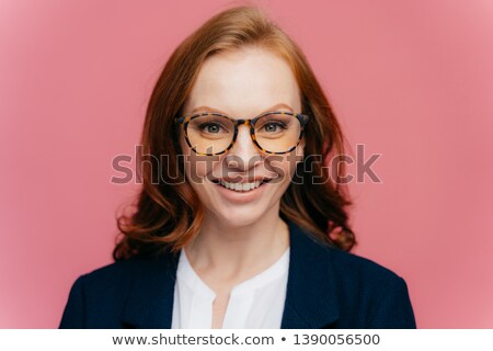 Foto stock: Close Up Shot Of Beautiful Redhead Gorgeous Woman In Optical Glasses Has Toothy Smile Dressed In E