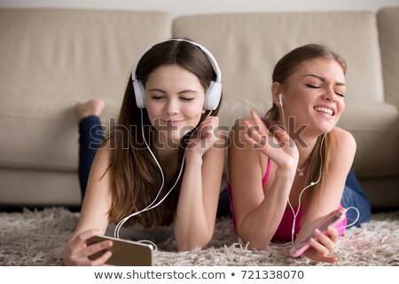 Foto stock: Attractive Teen Girl Listening Music Lying On A Sofa