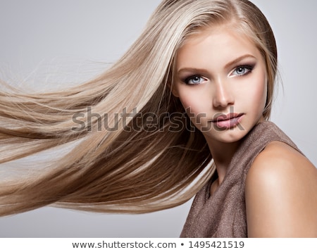 Foto stock: Posing Blond Woman With Long Hair On Grey