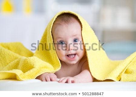 Foto stock: Indo · bebé · sonriendo · cubierto · de · toalla · amarilla