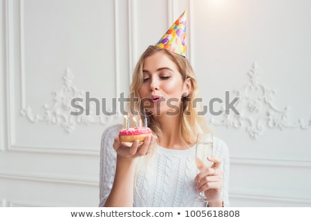 Stockfoto: Woman Holding Donut And Blowing On Candle