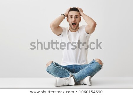 Foto d'archivio: Stylish Man Sitting In Studio Background Legs Crossed Holding Hi