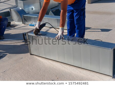 Foto stock: Young Technician Cutting A Pipe