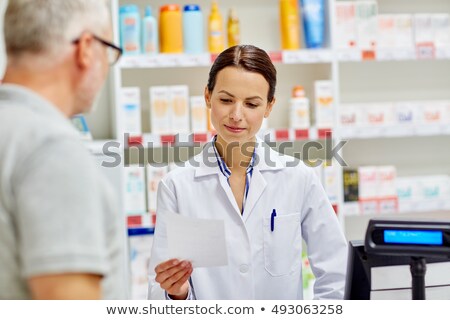 Stock photo: Senior Apothecary Reading Prescription At Pharmacy