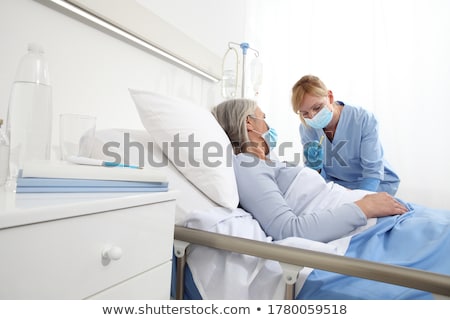 Stockfoto: Nurse Caring For Patient In Recovery Room Of Hospital