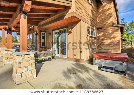 Stockfoto: Home Exterior With Spacious Back Patio Hot Tub And Barbecue