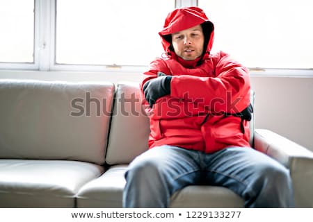 Stockfoto: Man With Warm Clothing Feeling The Cold Inside House On The Sofa