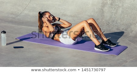 Stockfoto: Woman Doing Sit Ups On A Yoga Mat
