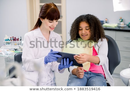 Zdjęcia stock: Pediatric Dentist Speaking With Little Girl In The Dentists Chai