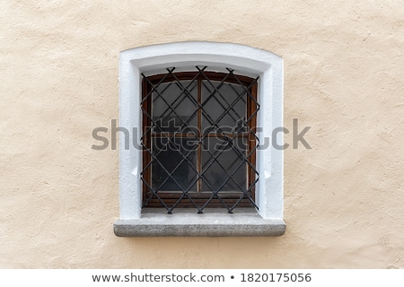 Stockfoto: Old Stone Wall With Small Iron Barred Prison Cell Window