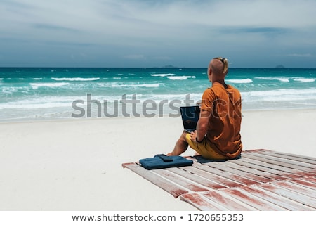 Foto stock: Male On A Beach Using His Computer