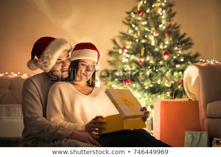 Foto stock: Happy Couple With Christmas Gift Hugging At Home