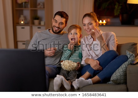 Foto stock: Father And Son With Popcorn Watching Tv At Home