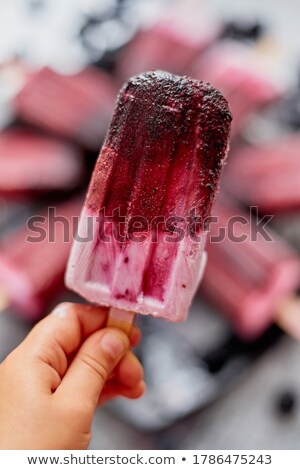 Foto stock: Close Up On Kids Hand Holding Colorful Blueberry Fruit Popsicle Healthy Summer Snack Concept