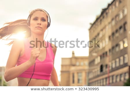 Stok fotoğraf: Young Beautiful Fitness Woman Running And Listening To Music