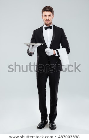 Stockfoto: Happy Young Waiter In Tuxedo Holding Serving Tray