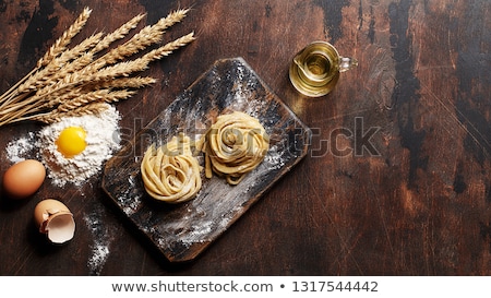 Stock photo: Raw Pasta Tagliatelle Spaghetti With Eggs On Wooden Background