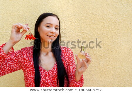 ストックフォト: Beautiful Young Woman In A Red Dress Spraying The Perfume