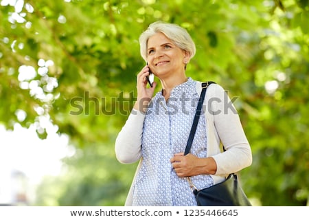 Foto stock: Happy Senior Woman Calling On Smartphone In Summer