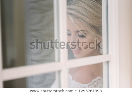 Stock fotó: Beautiful Blonde Woman In A Pink Dress At The Opened White Door