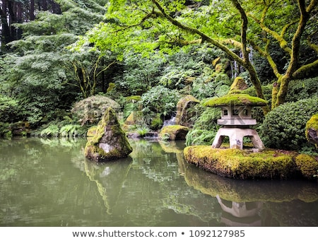 Foto stock: Japanese Stone Lantern By The Pond