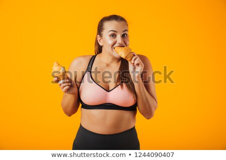 Foto stock: Image Of Young Chubby Woman In Tracksuit Eating Croissants Isol