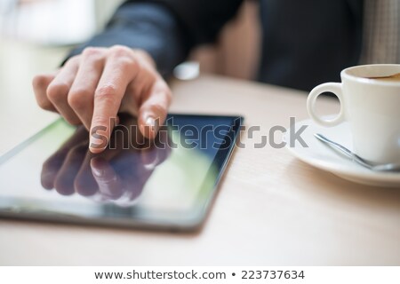 Foto stock: Man With Coffee And Tablet Computer Reading News At Motning