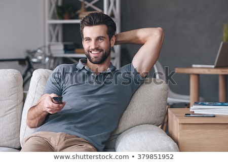 Stock fotó: Man Holding The Remote While Watching Tv