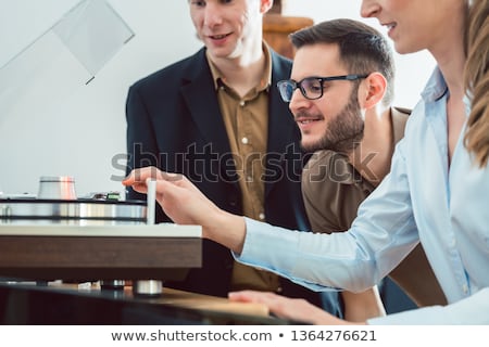 Stok fotoğraf: Couple Testing A Hi Fi System In The Store With The Salesman Explaining