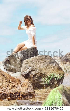 Stock fotó: Portrait Of A Girl Near The Sea Sitting On The Rocks With A Toy Ship In Hands