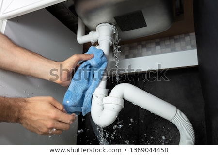 Stockfoto: Male Hands Holding Blue Napkin Under Leakage Pipe