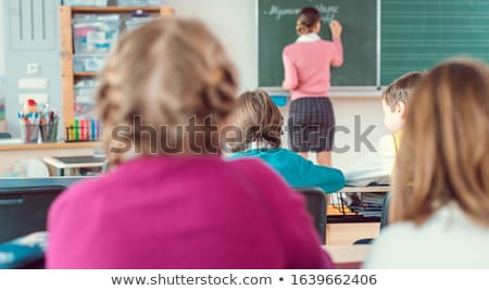 Foto stock: Teacher In Class With Fourth Grade Students In Front Of Black Board