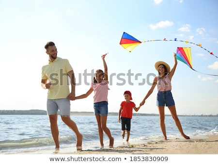 ストックフォト: Boy And Girl With Their Parents Play In Sand On Beach Sunny Autumn Day Build A Castle Of Sand