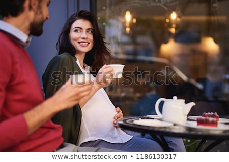 Stockfoto: A Pregnant Young Woman And Her Husband A Happy Family Sitting On A Swing Holding Belly Pregnant W