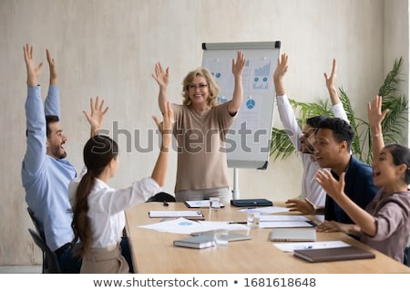 Foto stock: Overjoyed Emotional Female Entrepreneur Raises Hands Laughs Sincerely Wears Spectacles And Formal