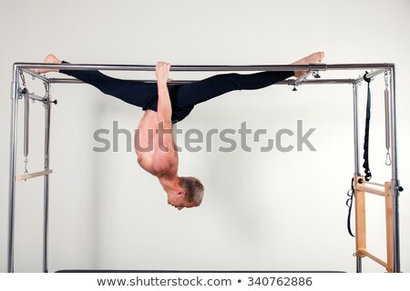Stock fotó: Pilates Woman In Cadillac Acrobatic Upside Down