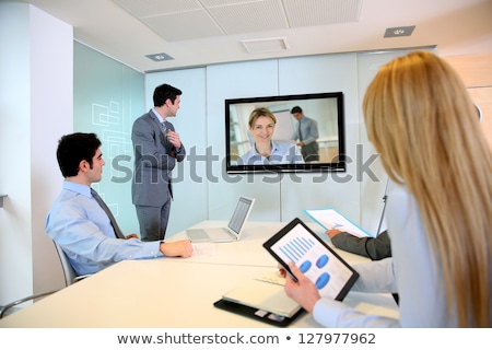 Foto stock: Businesspeople Attending Videoconference Meeting In Office