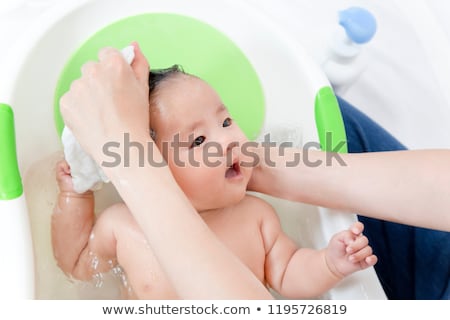 Stock photo: Washing The Head Of A Newborn Baby Under Water