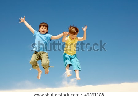 Deux garçons sautent sur le sable [[stock_photo]] © Pressmaster