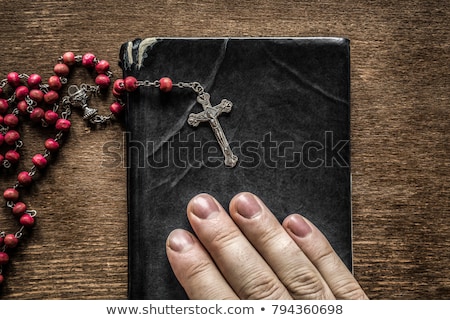 Foto stock: Hands With Rosary And An Old Book