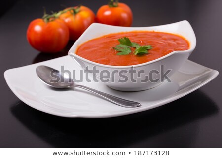 Stock photo: Black Restaurant Plate Of Creamy Tomato Soup On Black Table Background With Stone Chopping Board And