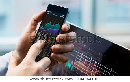 Foto stock: Stock Market Broker Using Mobile Phone