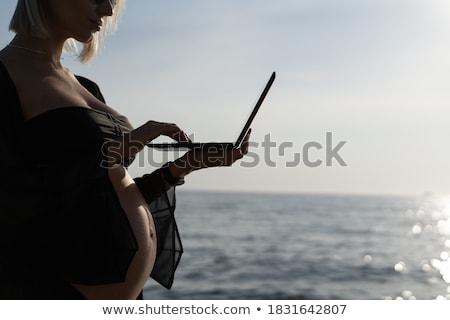 Stockfoto: Pregnant Woman Texting Outdoors